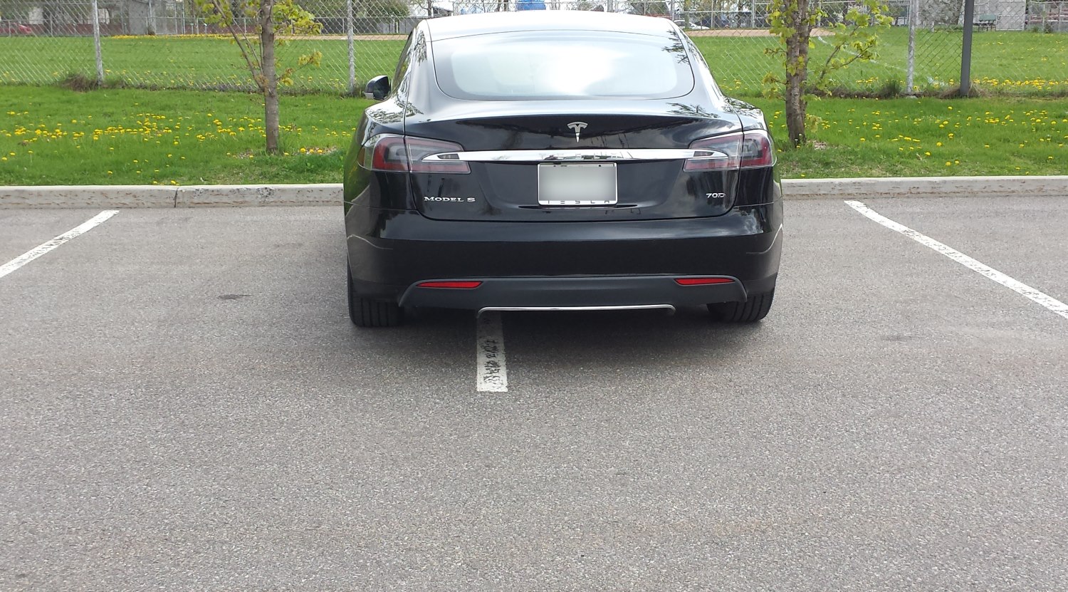 Une Tesla tout croche sur toute la ligne Tesla parké tout croche à Dorval